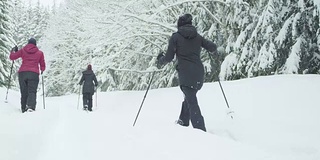 广角镜头的三个年轻的女士徒步在一个下雪天