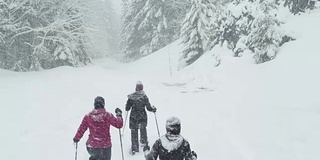 在一个下雪天，三个年轻的女士徒步旅行的镜头