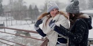 年轻美丽的女性站在和享受暴风雪在寒冷的冬日。