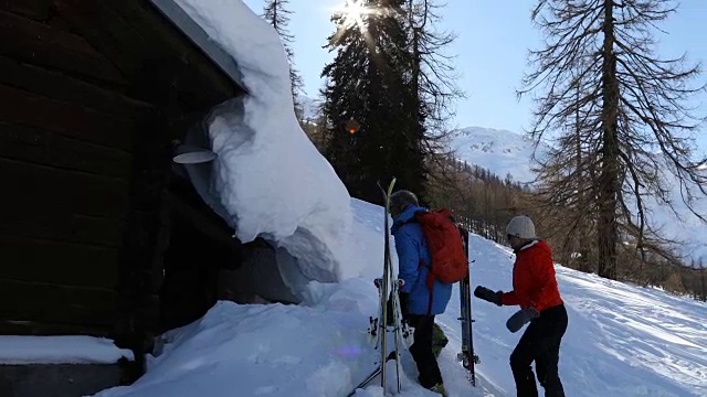 成熟的边远地区滑雪夫妇从山上小屋探索瑞士阿尔卑斯山