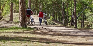 骑自行车的老夫妇在森林里散步