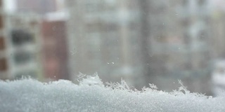 下雪的城市，从窗口近距离观看。雪落。