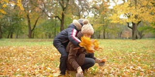 妈妈和儿子们在秋天的公园里玩耍