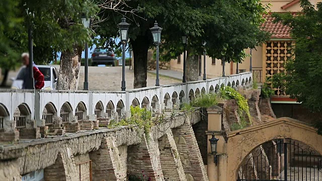 Cars and people on ancient stone bridge in Georgia, sightseeing architecture