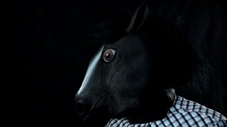 在黑色背景的慢动作中，用手捂住马的面具视频素材模板下载