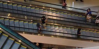 人们在现代购物中心的自动扶梯上活动。