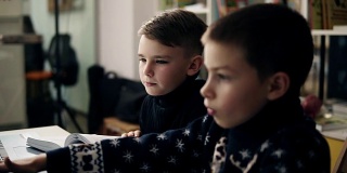 两个小男孩坐在笔记本电脑前的慢镜头。编程类。儿童的替代性教育。