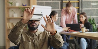 非裔美国人在游戏开发办公室测试VR模拟器。创业创意团队讨论未来虚拟现实技术项目