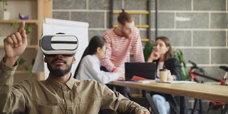 非裔美国人在游戏开发办公室测试VR模拟器。创业创意团队讨论未来虚拟现实技术项目