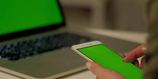 女孩用绿色屏幕触摸手机