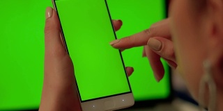 女士用绿色屏幕触摸手机