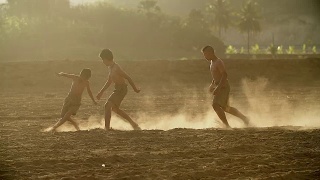 乡村的孩子们在阳光明媚的日子里踢足球。视频素材模板下载