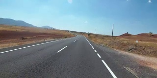 在西班牙，骑摩托车的人在风景优美的沙漠和空旷的道路上。第一个人的观点