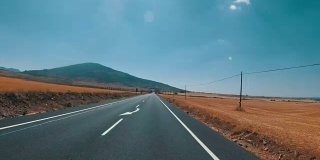 在西班牙，骑摩托车的人在风景优美的沙漠和空旷的道路上。第一个人的观点