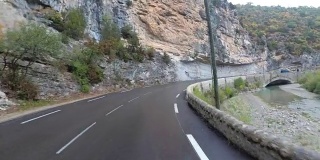 骑摩托车的人在法国美丽的风景山路上。多雨的天气。第一个人的观点
