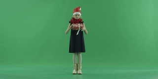 可爱的小女孩在圣诞帽看她的圣诞礼物盒，色度键的背景