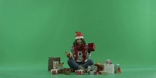 迷人的年轻女子在圣诞帽得到了空的圣诞礼物盒，色键的背景