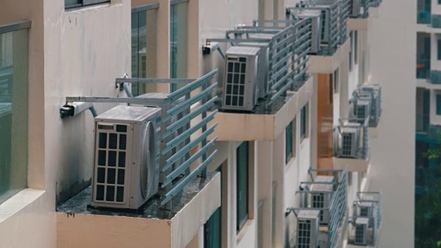 现代化的多层建筑与许多空调在雨中