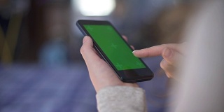 一名女性使用绿色屏幕的智能手机