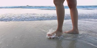 慢动作特写女人的腿在海滩上行走