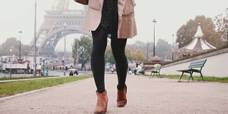 女性的脚做步骤的特写视图。法国巴黎，一个时尚的女人在雾蒙蒙的早晨走在埃菲尔铁塔上