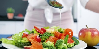 适当的营养，把橄榄油倒在蔬菜上，厨房里的新鲜有机沙拉