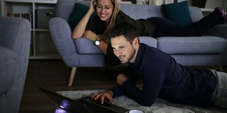 一对幸福的夫妇在家里用笔记本电脑上网