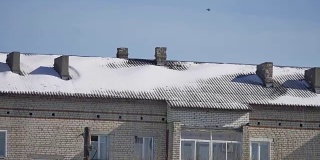 雪躺在一个多层老房子的屋顶冬季城市的户外景色