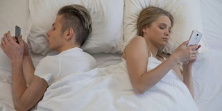 男人和女人把小玩意放在枕头下，在社交网络上交流