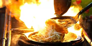 用铁锹在平底锅上翻炒炸虾的特写慢镜头，泰国传统食物，亚洲食物