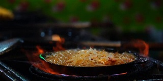 慢镜头的特写烹饪泰式炒米粉与虾在平底锅