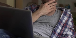 一个成年人坐在沙发上，拿着笔记本电脑，思考着未来的项目和计划