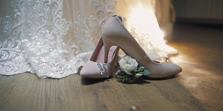 两个结婚戒指在新娘的结婚鞋附近滚动