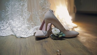 两个结婚戒指在新娘的结婚鞋附近滚动视频素材模板下载