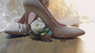 两个结婚戒指在新娘的结婚鞋附近滚动视频素材模板下载