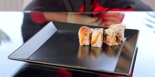 寿司卷把寿司放在一个黑色的盘子里
