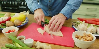 男人的手在切菜板上切鸡柳的特写