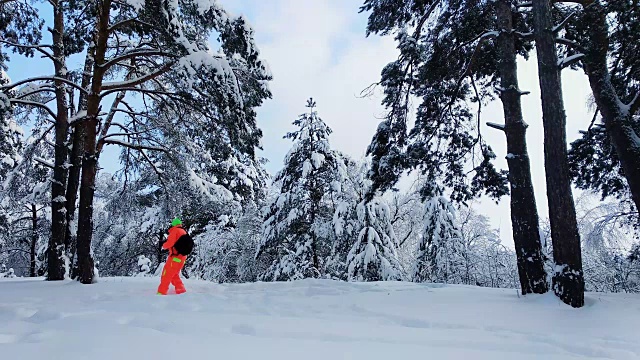 一个拿着相机的人正在拍摄冬天雪地里的森林。