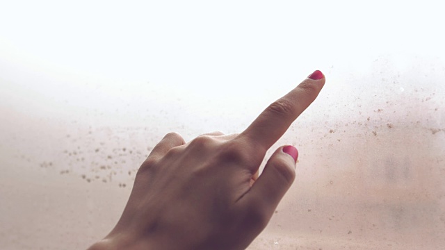 手画心与手指上的蒸窗在一个雨天的特写