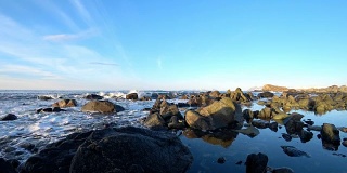 美丽的冬日里，挪威北部罗浮敦群岛Austvågsøya岛上，海浪拍打着岩石。