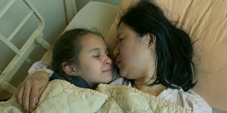 幸福的孩子在病床上亲吻母亲