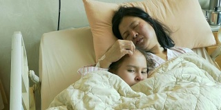 小女孩和生病的母亲躺在病床上