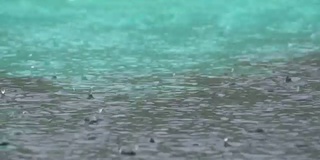 暴雨期间大雨滴落在水坑里。水滴