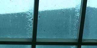 窗外的雨从玻璃上滴下来