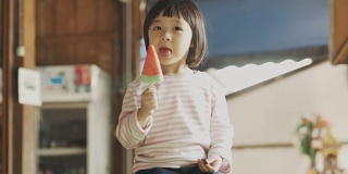 亚洲可爱的女孩正在吃西瓜形状的冰淇淋，情绪积极，放松，享受美食