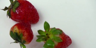 新鲜草莓落入奶油中的慢镜头