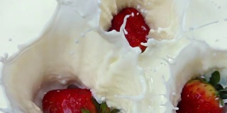 草莓落入奶油中的慢镜头