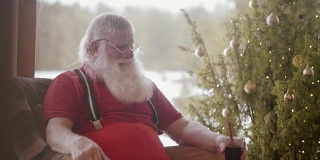 Modern Santa Claus drinking mulled wine (slow motion)
