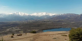 航拍:无人机飞越森林山谷湖，鸟瞰图上的阿尔卑斯雪山，晴朗的蓝天，都灵，意大利。