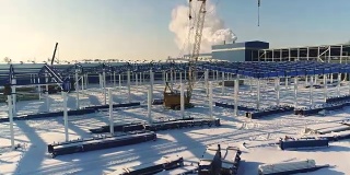 建设现代化工厂或厂房，工业区在冬季，从空中一览无余。现代化的厂房在白雪皑皑的田野上，新建了一座钢结构的商业建筑